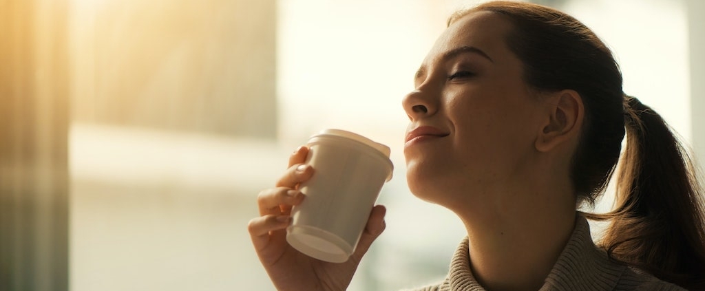 smiling-woman-drinking-coffee-with-eyes-closed