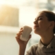 smiling-woman-drinking-coffee-with-eyes-closed