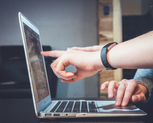 coworkers-looking-at-computer-screen-together