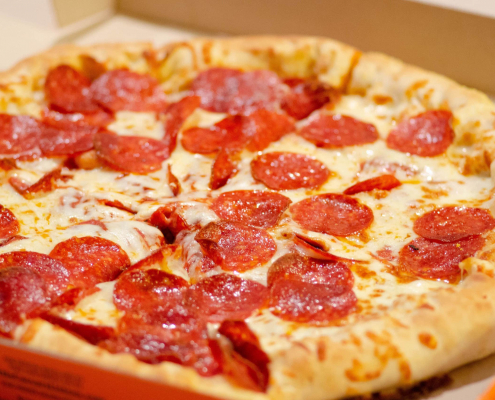 A close-up of a pepperoni pizza. It looks hot, and it looks ready.