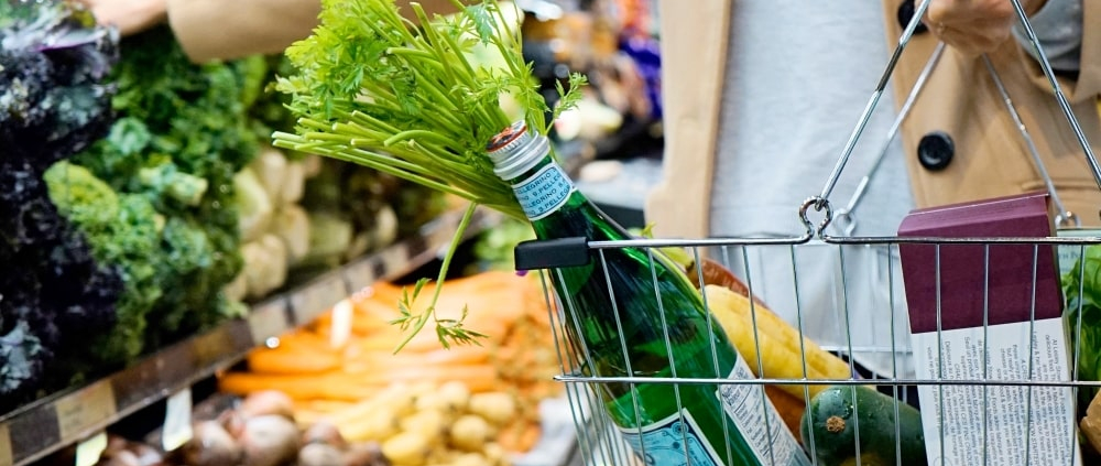 Lady picking out vegetables at grocery store