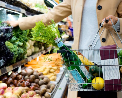 Lady picking out vegetables at grocery store
